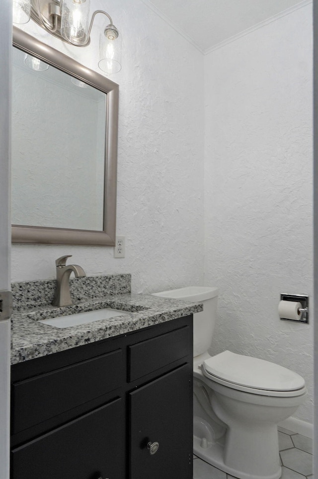 half bath with a textured wall, vanity, toilet, and ornamental molding