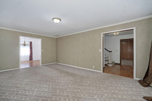 carpeted empty room featuring a chandelier, stairs, crown molding, and baseboards