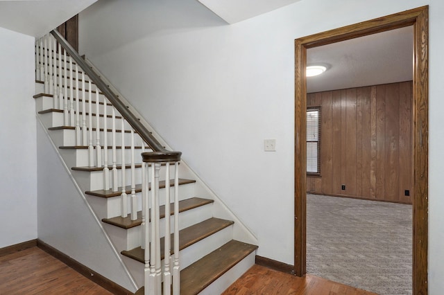 staircase with wood finished floors and baseboards