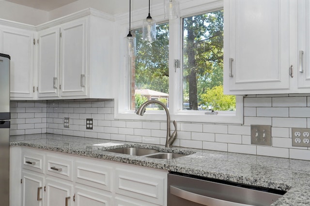 kitchen featuring dishwasher, a sink, white cabinets, decorative light fixtures, and backsplash