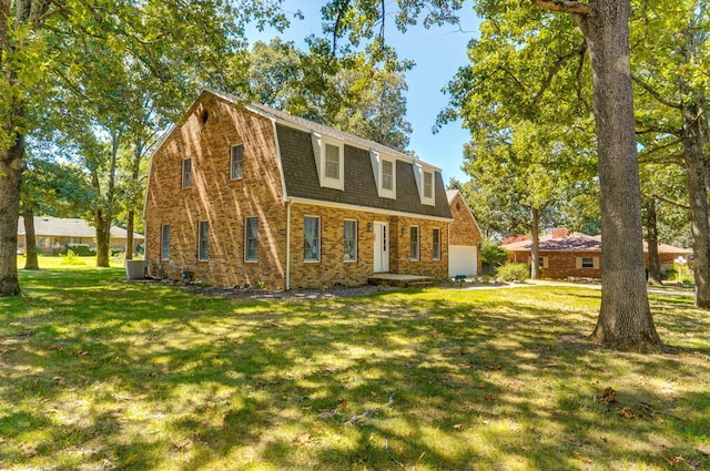 back of house featuring a gambrel roof, central AC, brick siding, and a yard