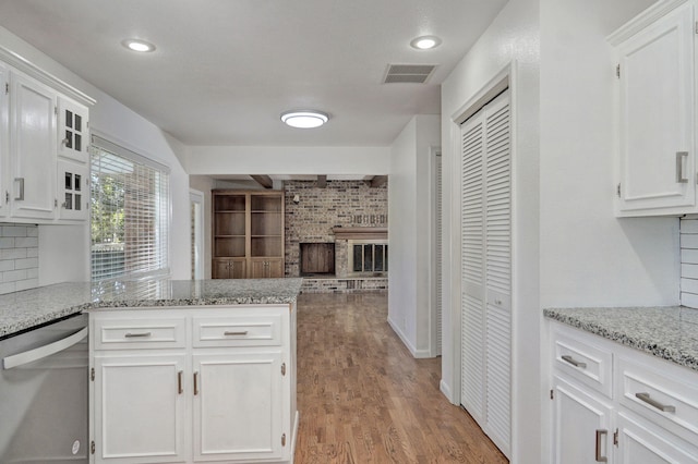 kitchen featuring dishwasher, white cabinets, open floor plan, a peninsula, and recessed lighting