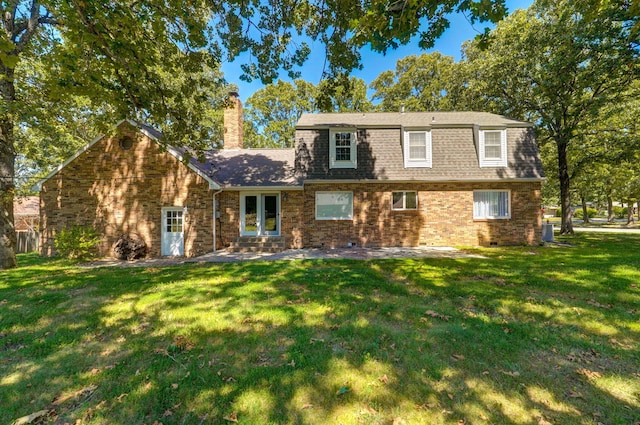 view of front of property with a chimney, a front lawn, a patio area, and brick siding