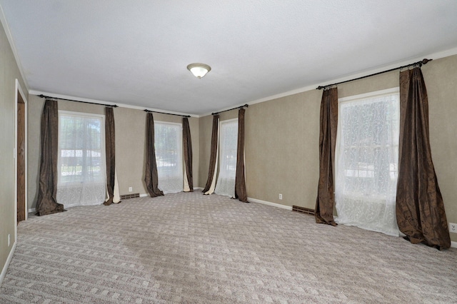 carpeted spare room with crown molding and baseboards