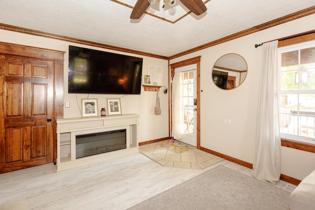 111 W Olive St, El Dorado Springs, MO 64744 - entrance foyer featuring ceiling fan, a textured ceiling, baseboards, a glass covered fireplace, and light wood finished floors