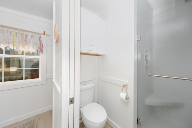 111 W Olive St, El Dorado Springs, MO 64744 - bathroom featuring a stall shower, toilet, and baseboards
