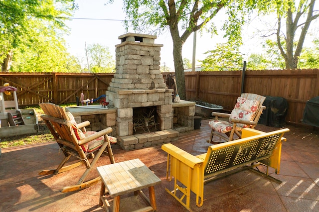 111 W Olive St, El Dorado Springs, MO 64744 - view of patio featuring an outdoor stone fireplace and a fenced backyard
