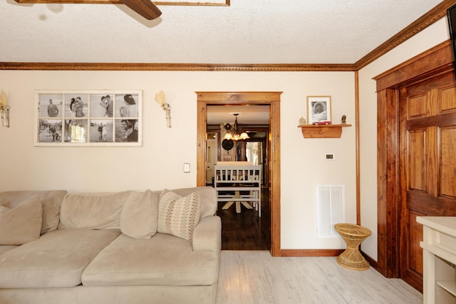111 W Olive St, El Dorado Springs, MO 64744 - living room with light wood-style flooring, a ceiling fan, a chandelier, crown molding, and a textured ceiling