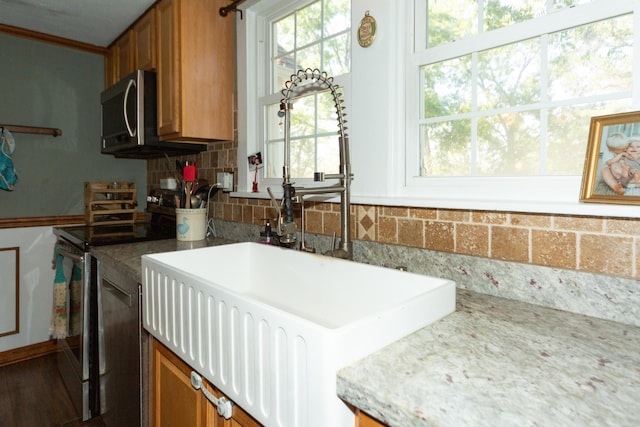 111 W Olive St, El Dorado Springs, MO 64744 - kitchen featuring electric stove, brown cabinets, plenty of natural light, and decorative backsplash