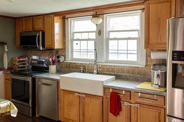 111 W Olive St, El Dorado Springs, MO 64744 - kitchen with stainless steel appliances, backsplash, brown cabinets, and a sink