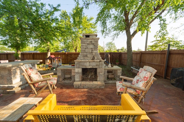 111 W Olive St, El Dorado Springs, MO 64744 - view of patio with an outdoor stone fireplace and a fenced backyard
