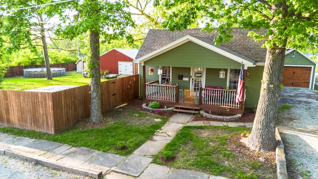 111 W Olive St, El Dorado Springs, MO 64744 - bungalow-style house with roof with shingles, a porch, and fence