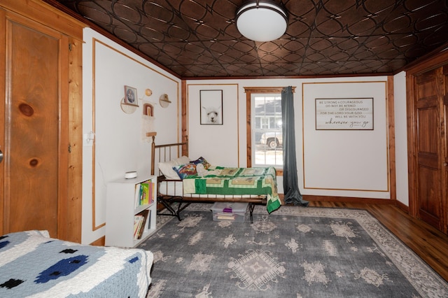 111 W Olive St, El Dorado Springs, MO 64744 - bedroom with an ornate ceiling, wood finished floors, and baseboards