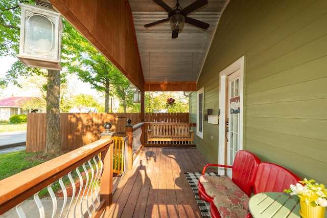 111 W Olive St, El Dorado Springs, MO 64744 - deck featuring a ceiling fan, covered porch, and fence