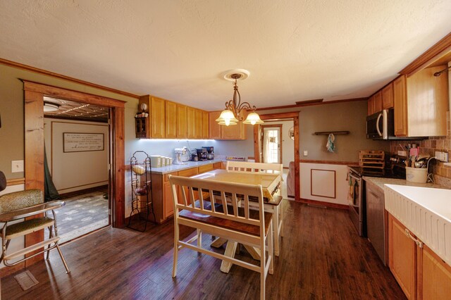 111 W Olive St, El Dorado Springs, MO 64744 - kitchen with appliances with stainless steel finishes, light countertops, dark wood-style floors, crown molding, and a chandelier