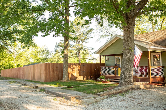 111 W Olive St, El Dorado Springs, MO 64744 - view of side of home featuring fence and a porch