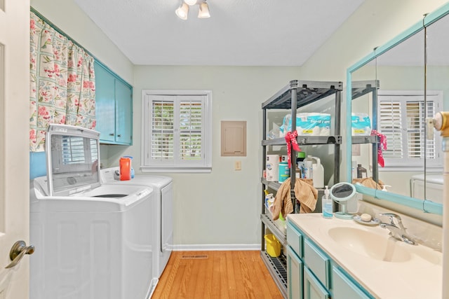 bathroom with washing machine and dryer, baseboards, wood finished floors, and vanity
