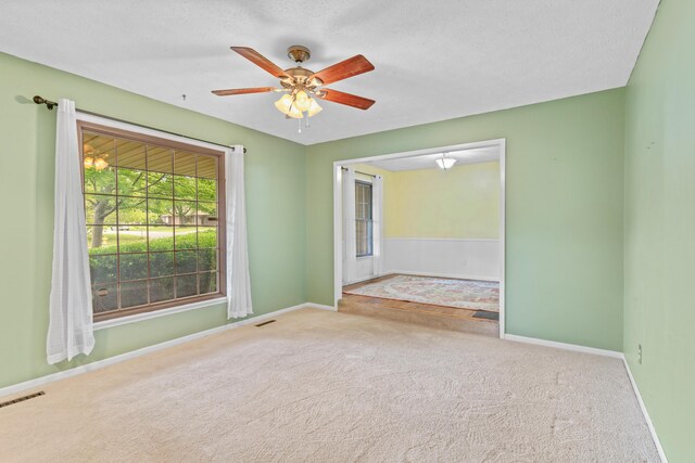 empty room featuring carpet floors, baseboards, and ceiling fan