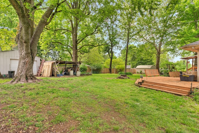 view of yard featuring an outdoor fire pit, a wooden deck, and an outdoor structure