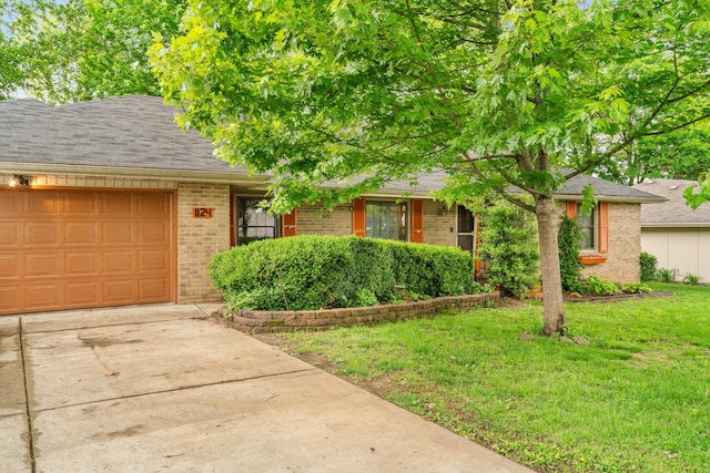 view of front of property featuring brick siding, a garage, concrete driveway, a front lawn, and a shingled roof