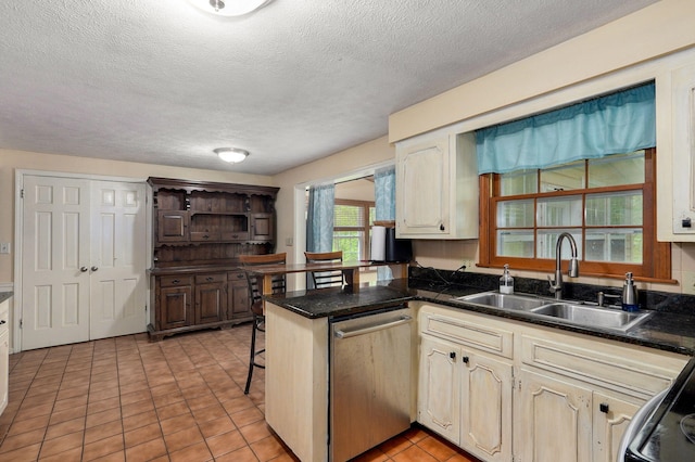 4855 E Cimarron Ln, Springfield, MO 65803 - kitchen featuring stainless steel dishwasher, a sink, a peninsula, a textured ceiling, and dark countertops