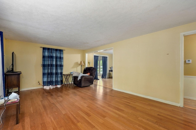 4855 E Cimarron Ln, Springfield, MO 65803 - living area featuring wood finished floors, a textured ceiling, and baseboards