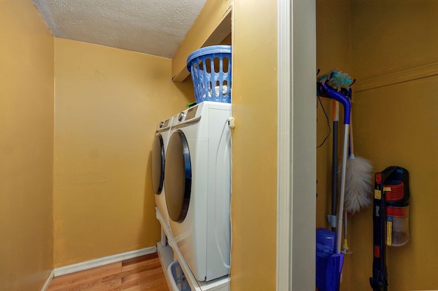 4855 E Cimarron Ln, Springfield, MO 65803 - washroom with light wood finished floors, a textured ceiling, washing machine and clothes dryer, and baseboards