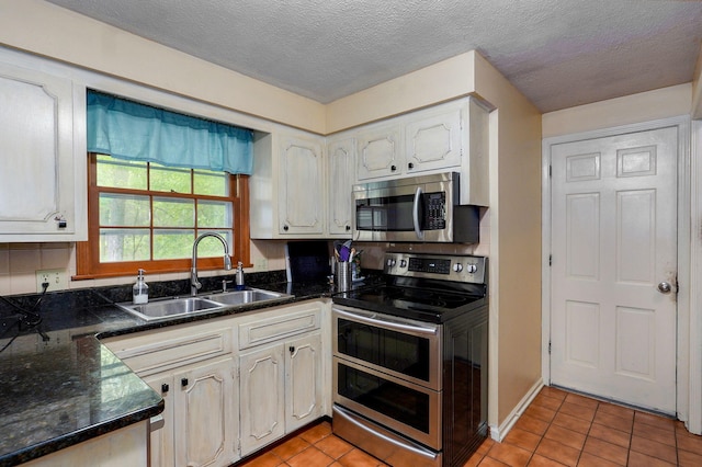 4855 E Cimarron Ln, Springfield, MO 65803 - kitchen featuring stainless steel appliances, a sink, light tile patterned floors, and a textured ceiling