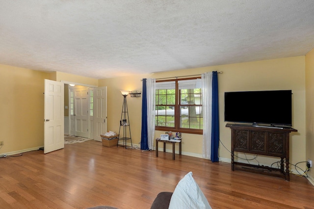 4855 E Cimarron Ln, Springfield, MO 65803 - living room featuring a textured ceiling, wood finished floors, and baseboards