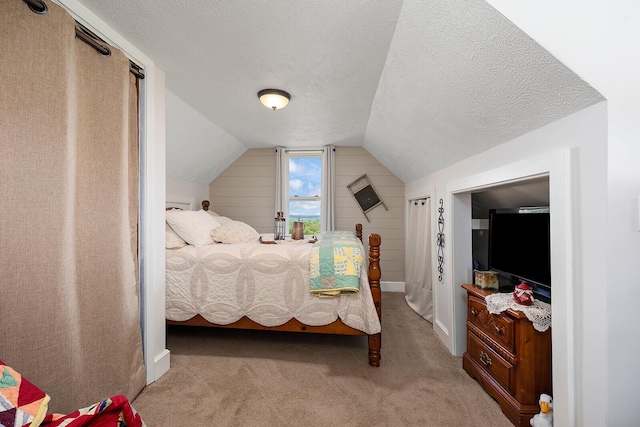 carpeted bedroom featuring lofted ceiling, a textured ceiling, and baseboards