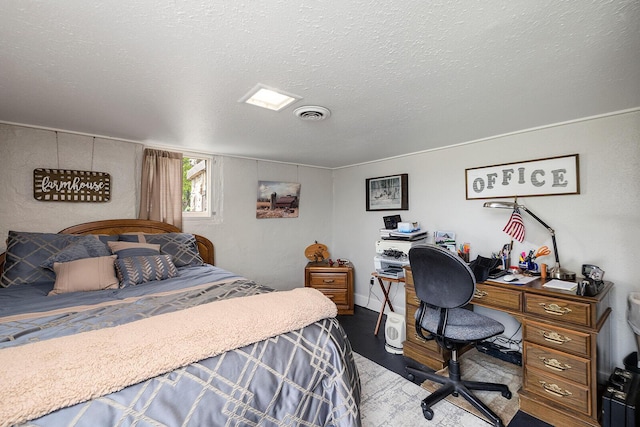 bedroom featuring a textured ceiling and a desk