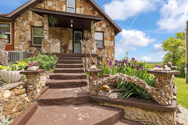 doorway to property with stone siding and central air condition unit