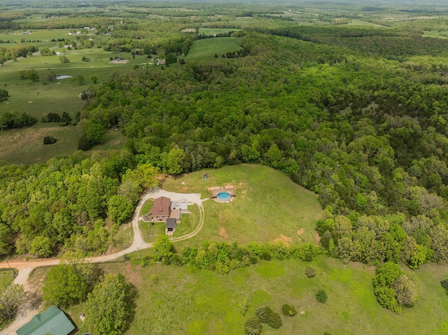 aerial view of property and surrounding area with a heavily wooded area