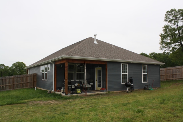 rear view of house featuring a shingled roof and a patio