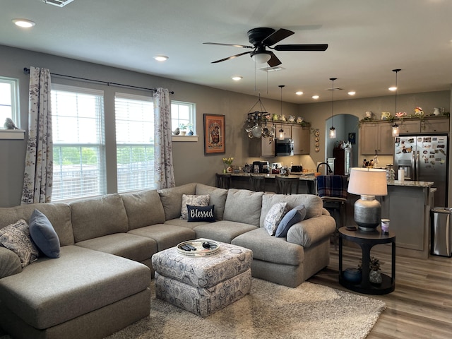 living area with light wood finished floors, a ceiling fan, and recessed lighting