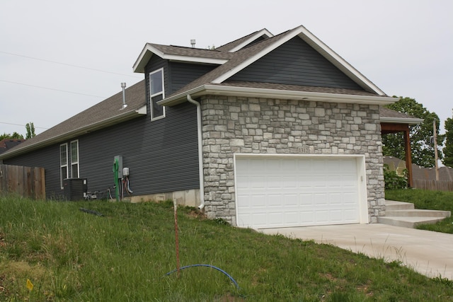 view of property exterior with stone siding, driveway, central air condition unit, roof with shingles, and an attached garage