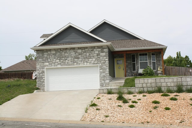 view of front facade featuring stone siding, fence, a garage, driveway, and a shingled roof