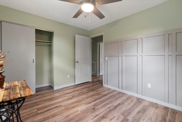 79 County Road 101, Gainesville, MO 65655 - unfurnished bedroom featuring light wood-type flooring, a closet, a decorative wall, and a ceiling fan