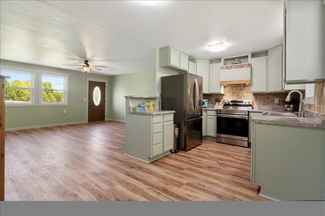 79 County Road 101, Gainesville, MO 65655 - kitchen featuring stainless steel appliances, a sink, decorative backsplash, ceiling fan, and light wood-style floors