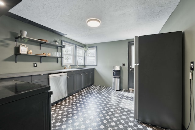 kitchen featuring stainless steel appliances, a sink, tile patterned floors, a textured ceiling, and gray cabinetry