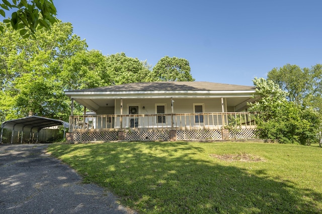 farmhouse-style home with a porch, a front yard, a detached carport, and driveway