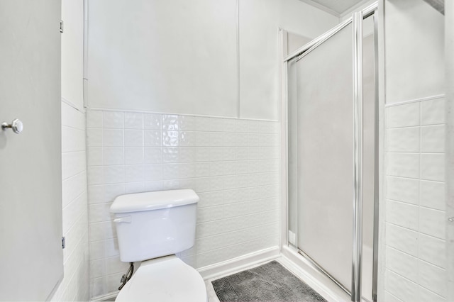 bathroom featuring a stall shower and toilet