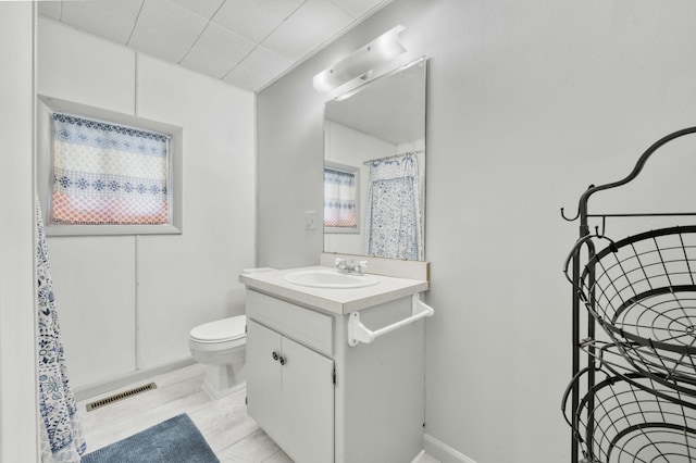 full bathroom featuring vanity, toilet, curtained shower, and baseboards