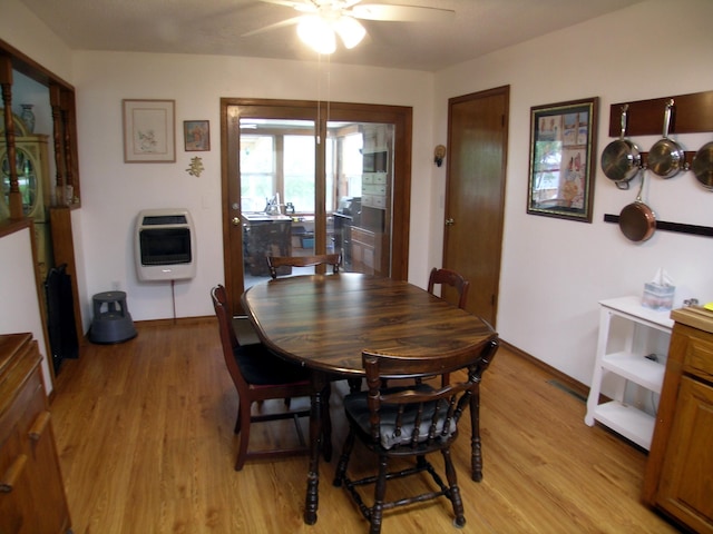 dining space with heating unit, a ceiling fan, light wood-type flooring, and baseboards