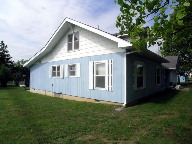 view of side of home with a lawn