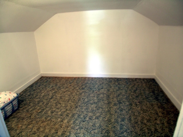 bonus room featuring lofted ceiling, baseboards, and carpet