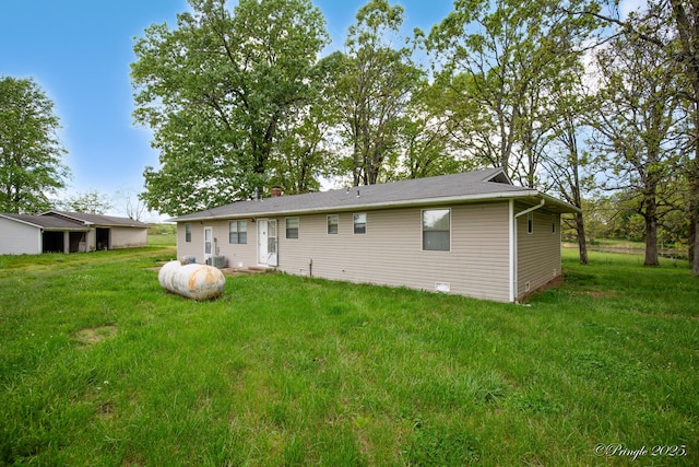back of house featuring a lawn and central AC