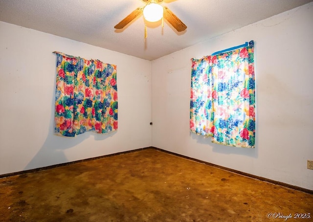 empty room featuring a ceiling fan, baseboards, and concrete flooring