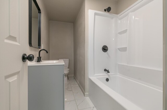 bathroom featuring marble finish flooring, toilet, vanity, bathing tub / shower combination, and baseboards