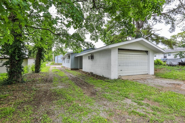 detached garage featuring dirt driveway